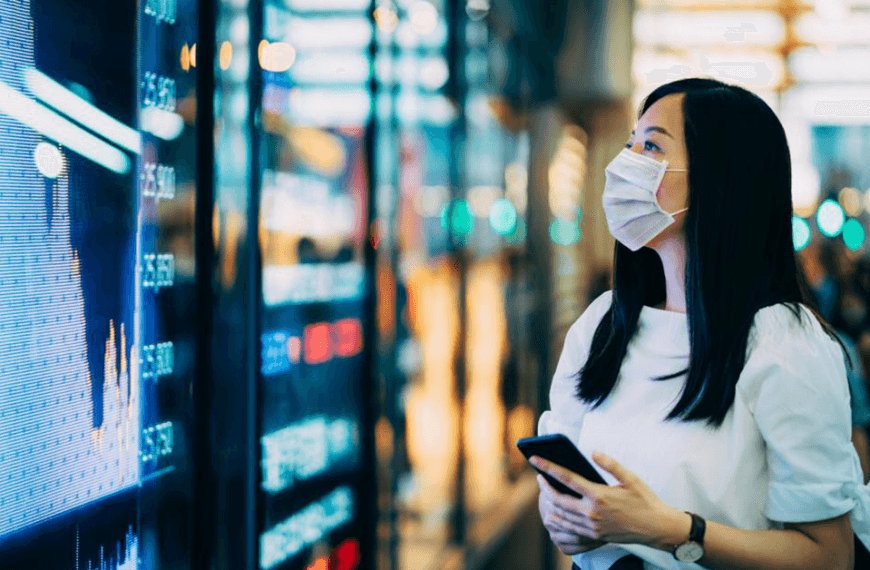 Woman with mask looks at financial data