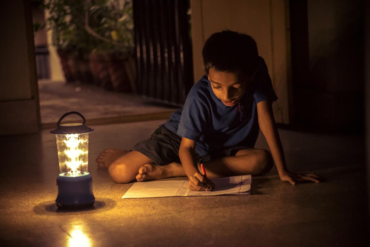 Child works by solar lamp