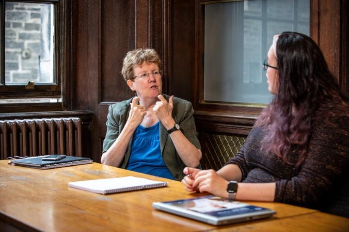 Two staff members converse in BSL