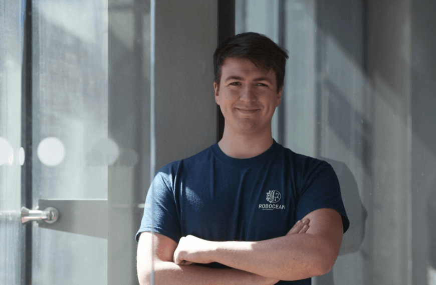 Niall McGrath, Engineering graduate and founder of Robocean stands with crossed arms smiling to camera