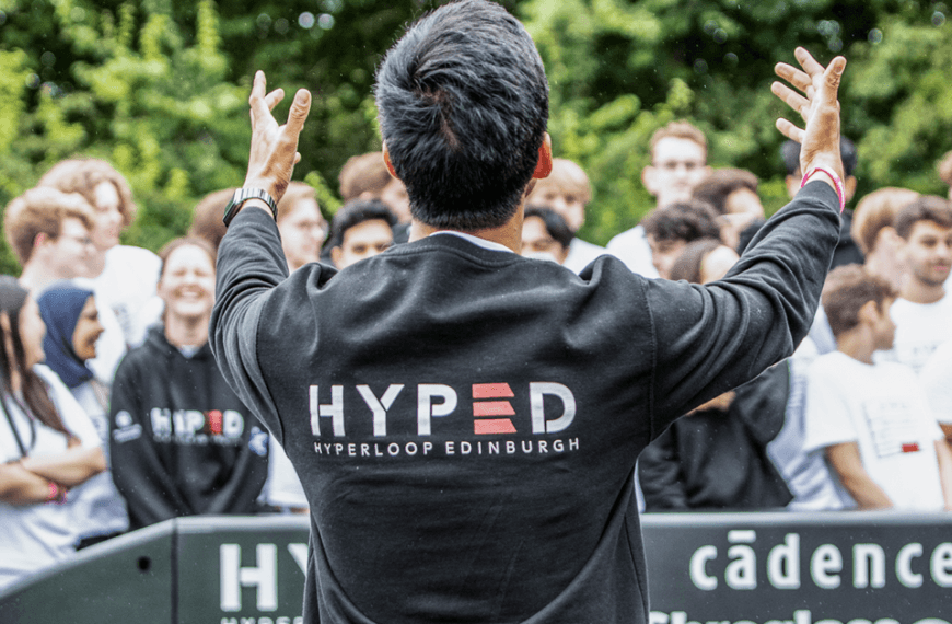 A man wearing a Hyped top looks onto a crowd