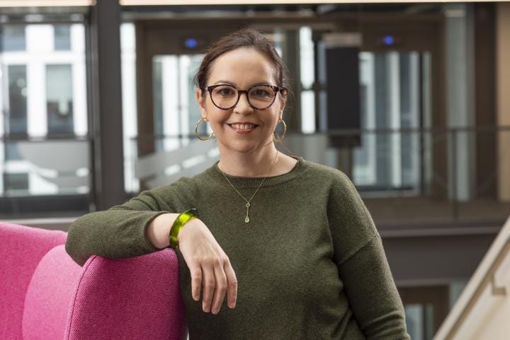 Professor Shannon Vallor in the University's Bayes Centre leaning against a pink chair