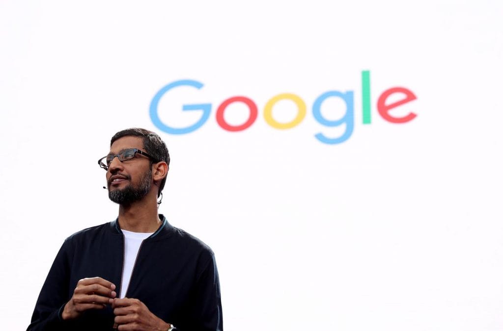 Profile picture of Sundar Pichai on stage in front of the Google logo.