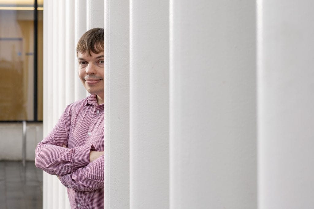 Academic standing outside the University of Edinburgh.