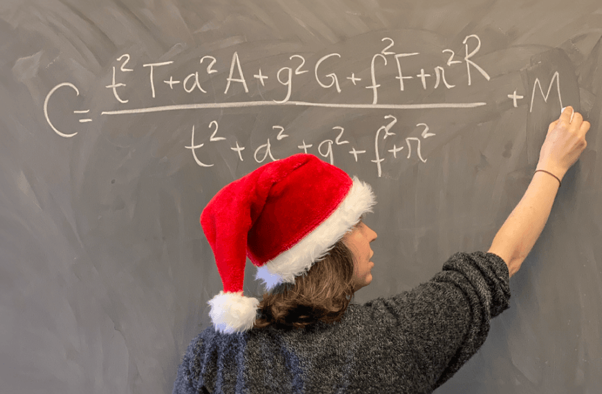 Dr Ana Rita Pires writes the perfect Christmas formula on a chalkboard. She is wearing a santa hat.