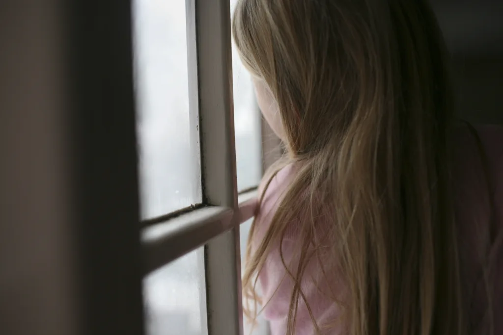 A young child looking out of a window 
