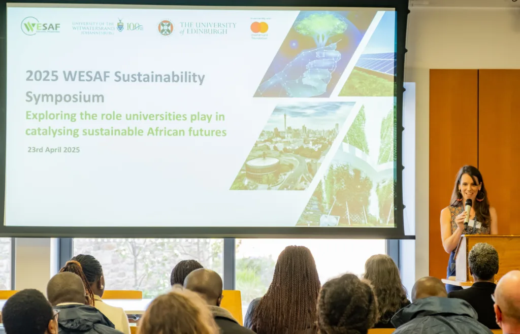 A woman introduces a panel discussion during the 2025 WESAF Sustainability Symposium in Edinburgh.