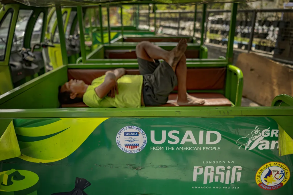 Man lies on disused truck with USAID on side
