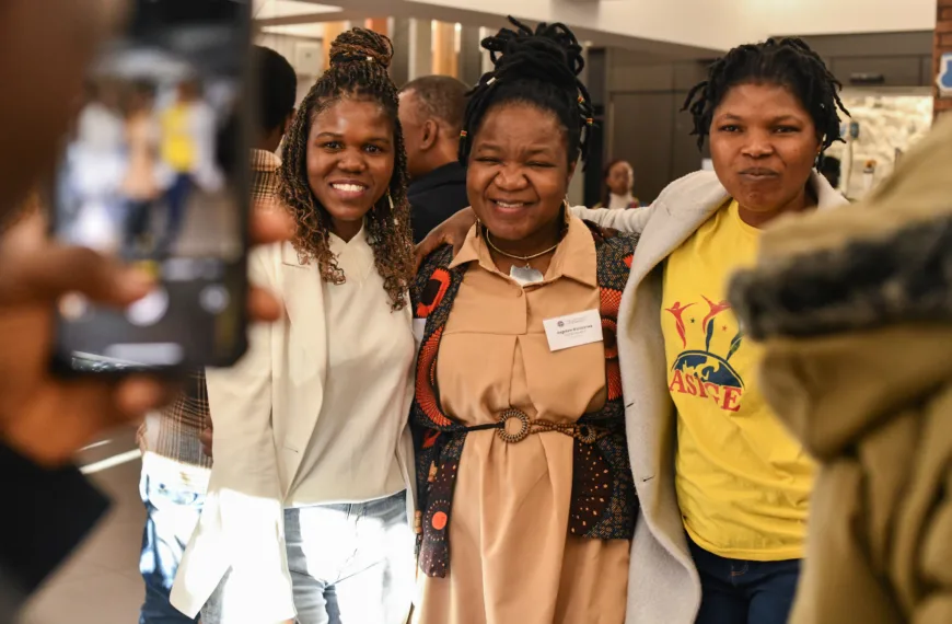 A group pose for a photo at a Mastercard Foundation event.