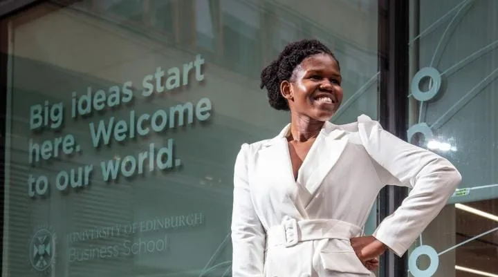 A woman poses for a photograph outside the University.