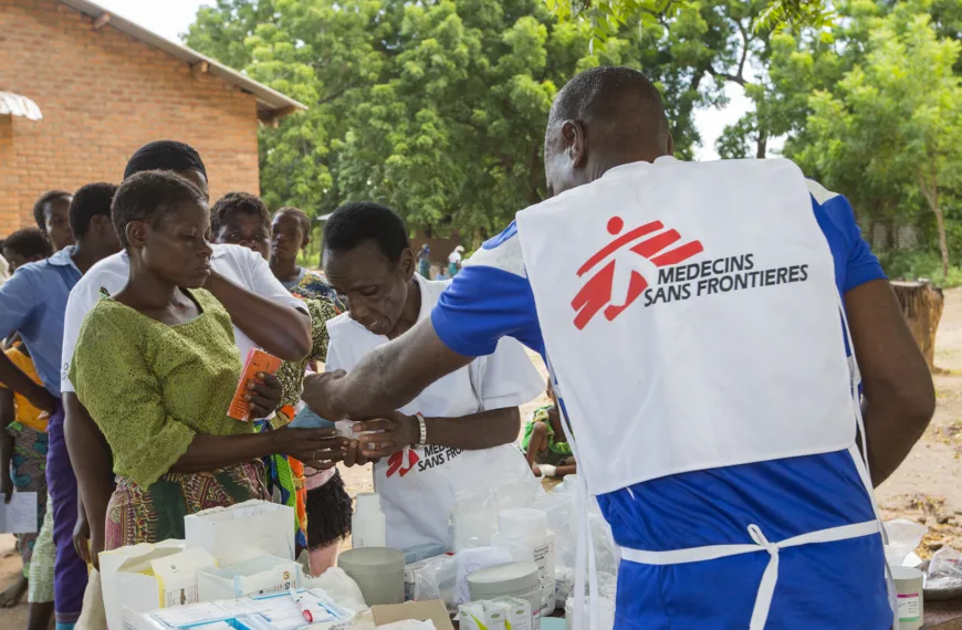A Medecins Sans Frontières aid worker distributes malaria treatment drugs to flood victims in Malawi