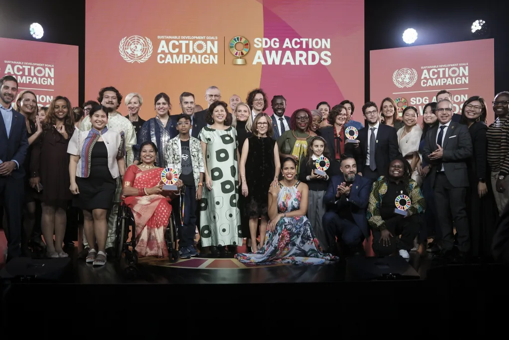 A crowd of UN colleages posing with an award at the Sustainable Development Goals Action Awards