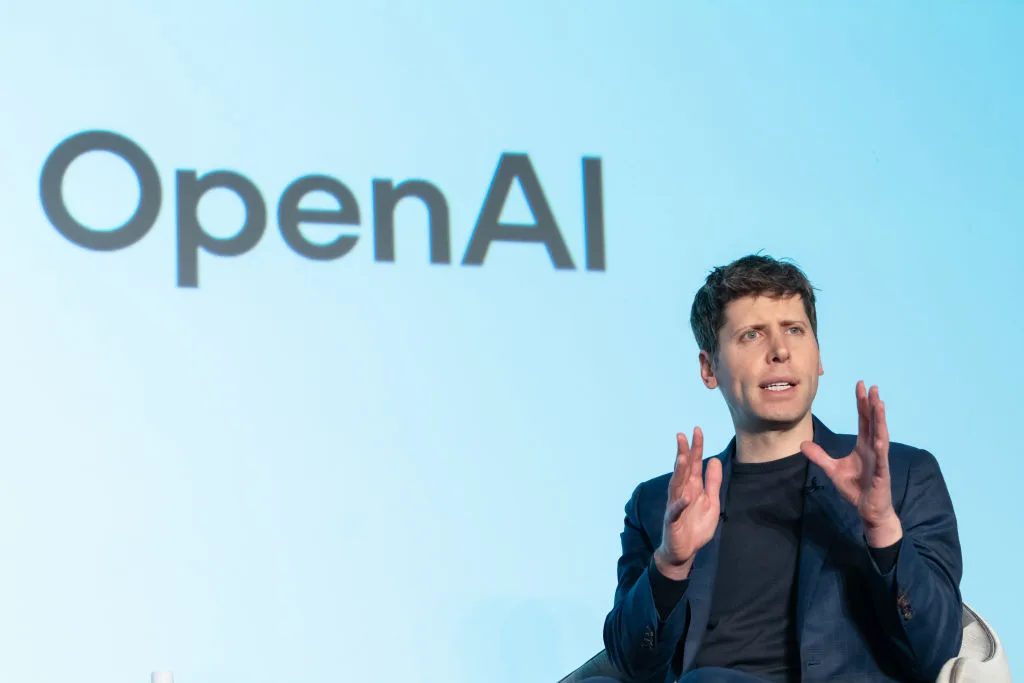 Sam Altman talking with the words "OpenAI" behind him.