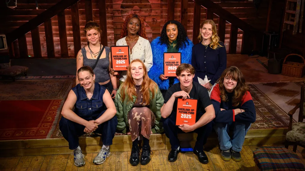 A group of young artists pictured with together, they are holding certificates that confirm they are the recipients of development funding from the venue.
