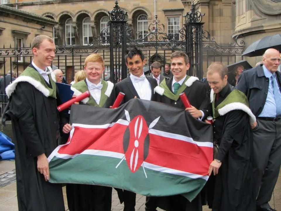 Five male graduates posing with the Kenyan flag
