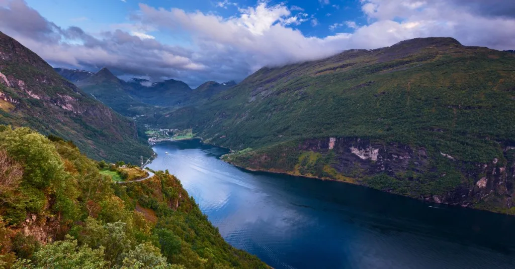 A sunny landscape image of Ghana with green hills and water