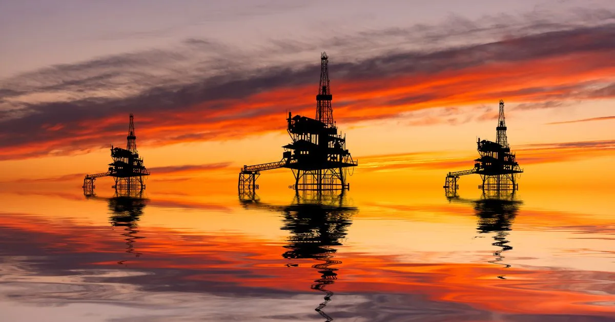 Three oil rigs at sunset