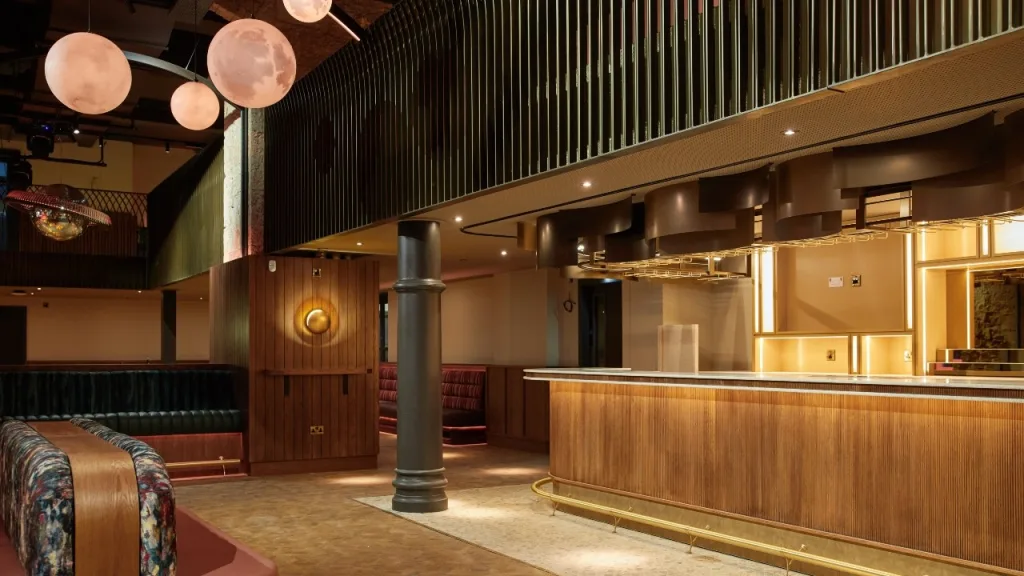 An interior view of the new Union Social bar and cafe, showing a light wood paneled bard area, soft furnishings and balcony. 