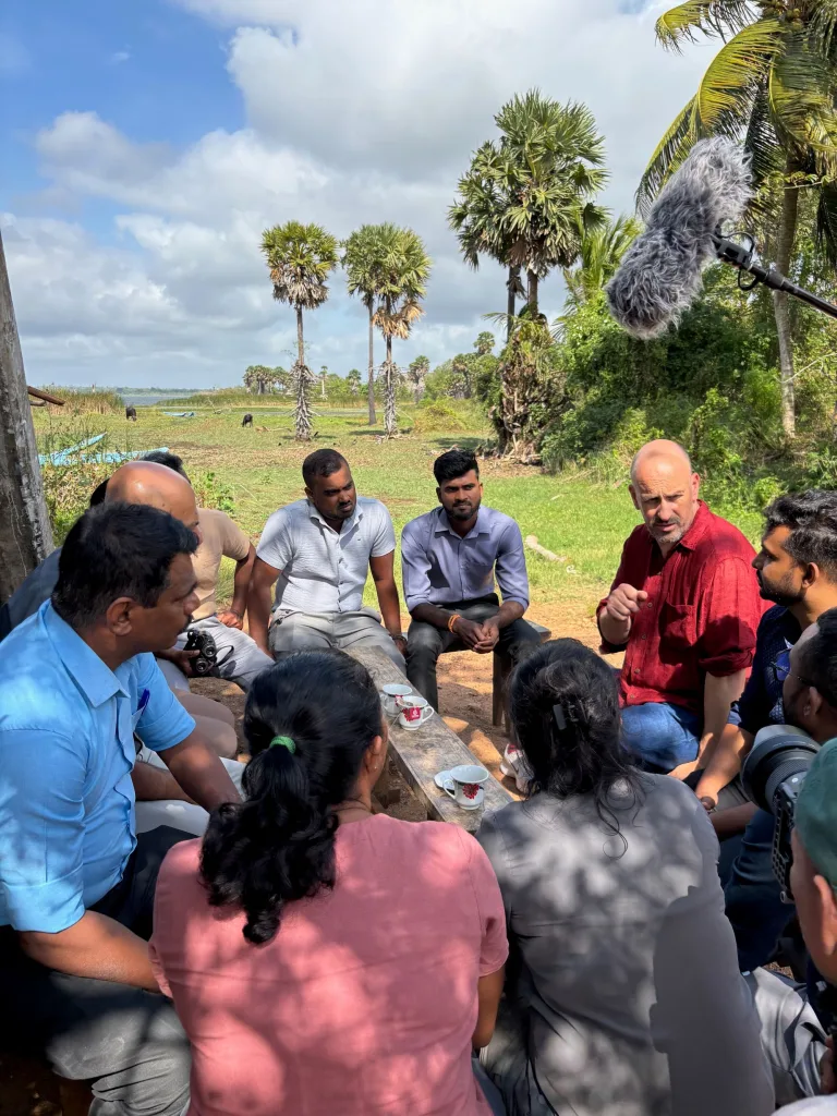 Michael Eddleston sitting having tea with members of the team in Sri Lanka