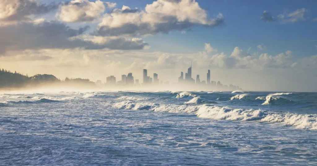 Ocean with blue sky and tall city buildings in the background